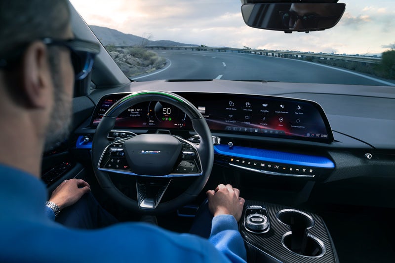 Front View of the 2026 OPTIQ-V Driving Through the Dusk Utilizing its Headlights | Schepel Cadillac in Merrillville IN